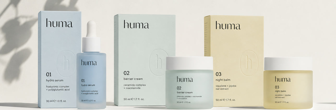 huma lineup — i tre prodotti allineati in ordine 01 hydro serum, 02 barrier cream, 03 night balm. Vetro satinato tinto in massa nei toni Blue, Sage e Sand, tappo Cap White. Concept brand identity e packaging di GG Creative Studio (2026).